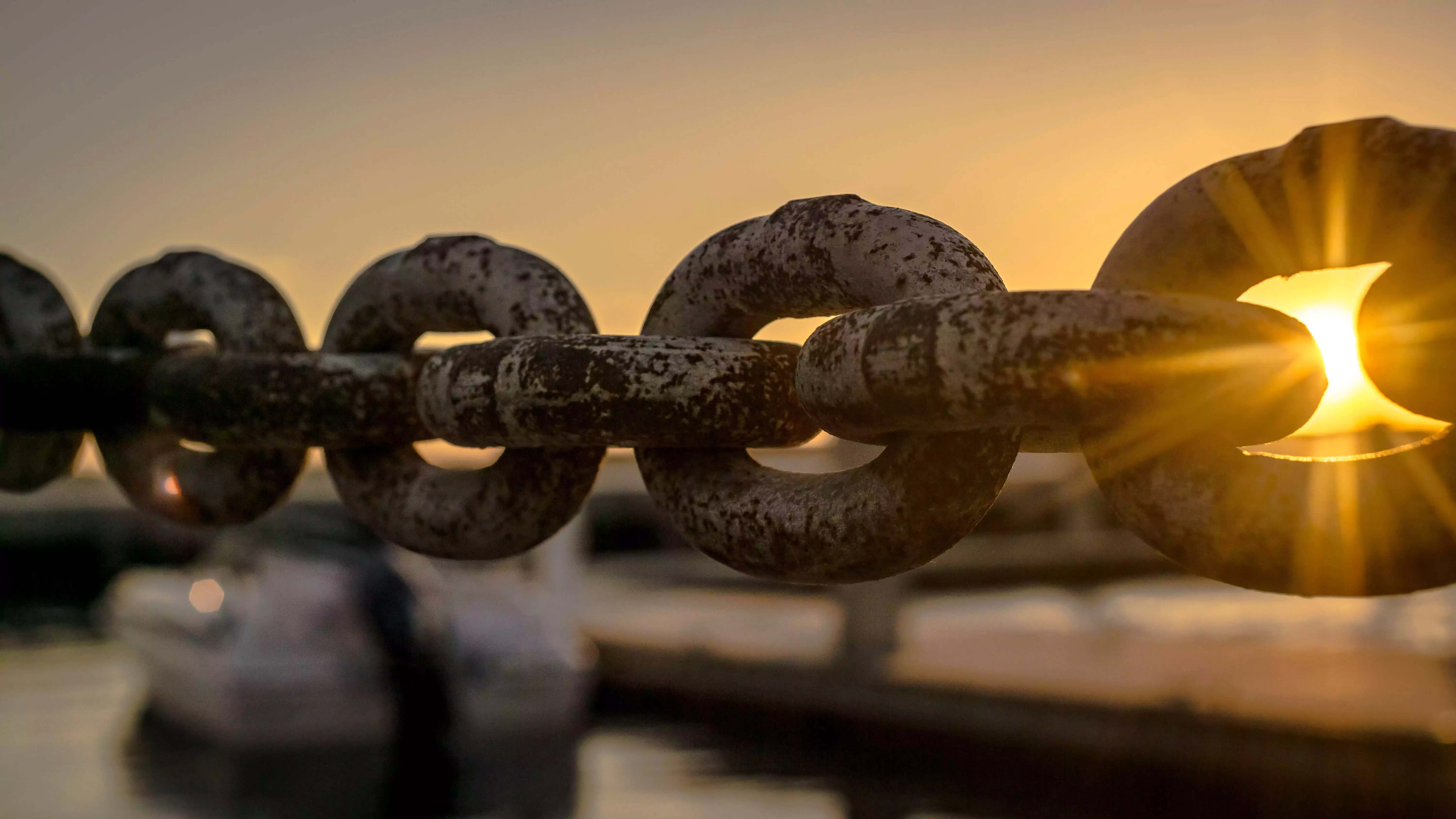 A chain in front of a sunset.